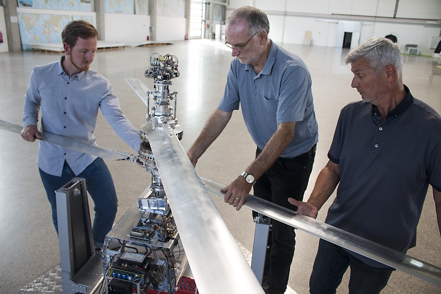 Max Elfgen, Erik Grädener und Frank Brennecke (v.l.) bringen die vier anderthalb Meter langen Rotorblätter an der Achse an.