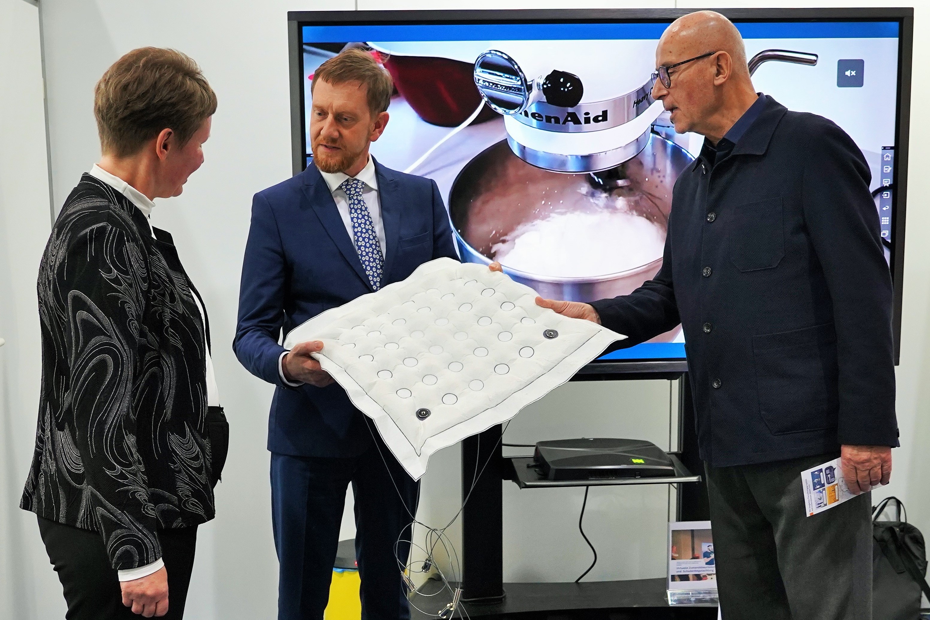 Petra Erth von der Textilausrüstung Pfand GmbH und Vogtlandpioniere-Berater Franz Rudolph zeigen Michael Kretzschmer einen Prototyp des Schaumgipsmoduls.