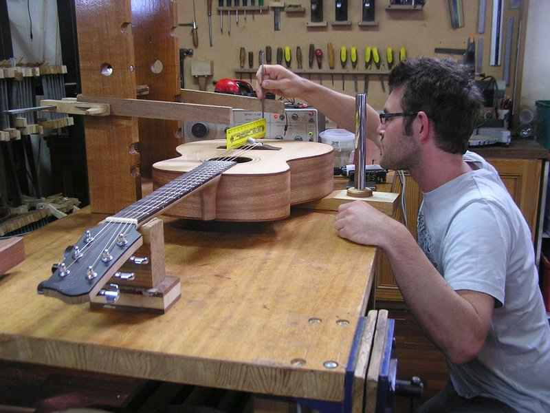 Mann baut eine Gitarre zusammen